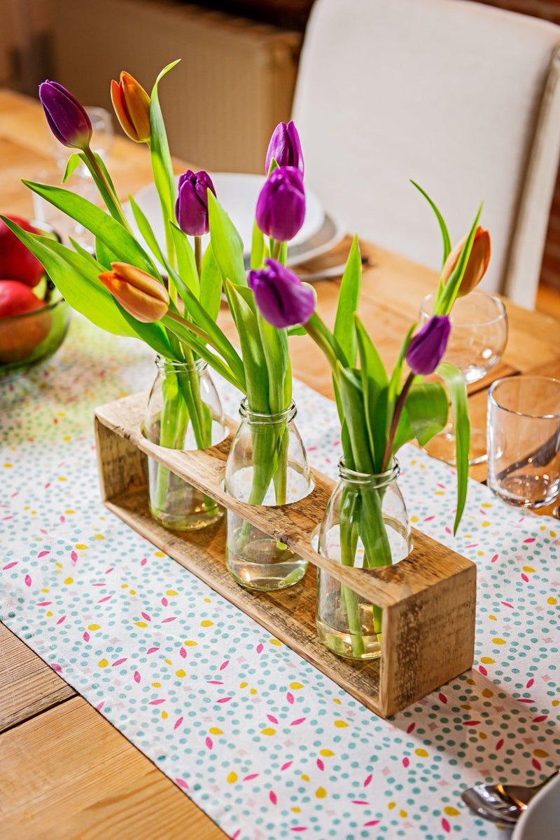 Blumenbank aus Holz mit drei Vasen bzw. Glasflaschen